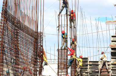 Ouvriers de construction travaillant sur l'armature en acier d'un grand bâtiment