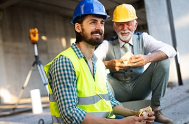 Deux ouvriers souriants en pause sur un chantier de construction